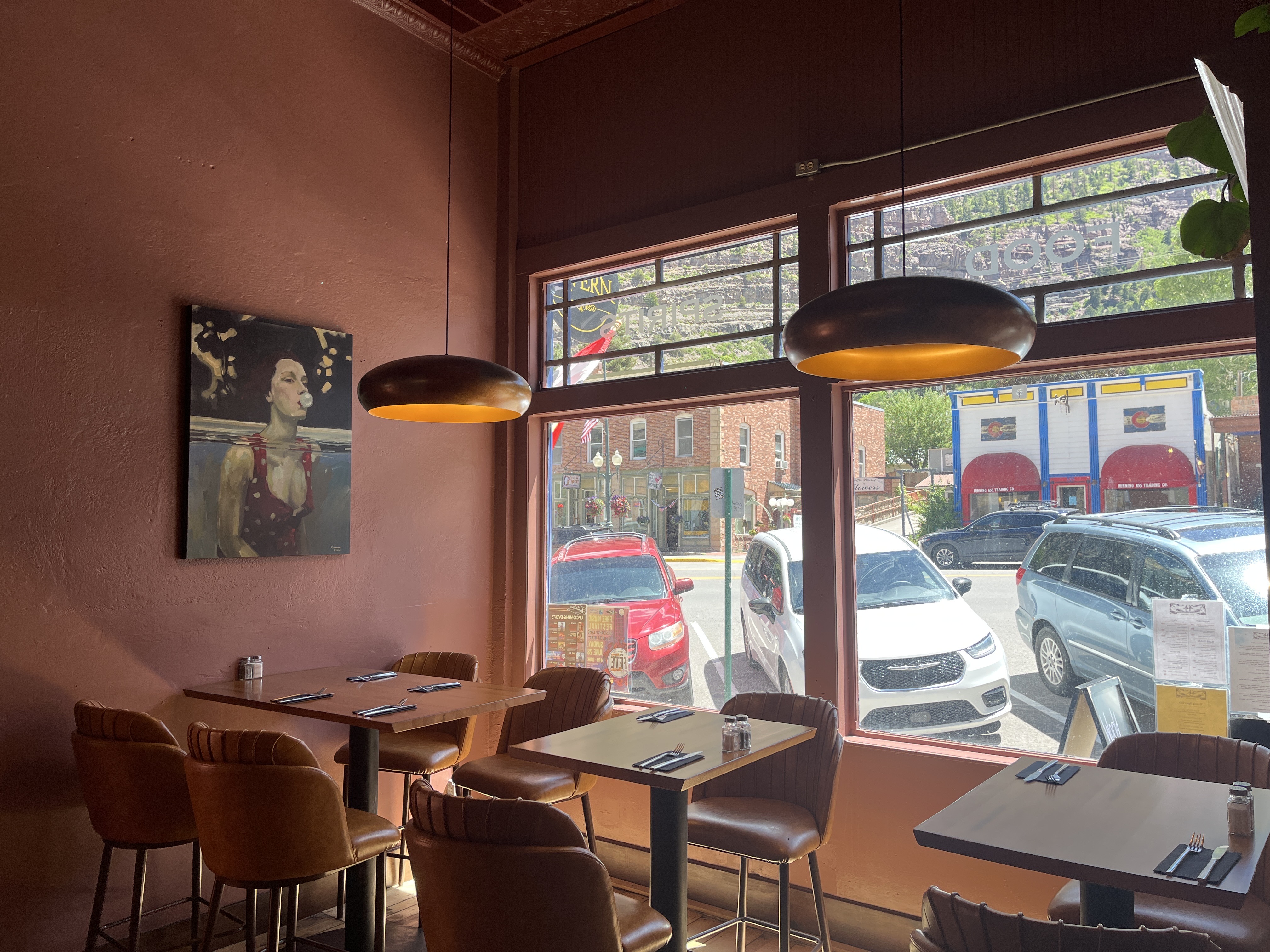 The Tavern dining room — warm pendant lights, leather chairs and artwork on terracotta walls.