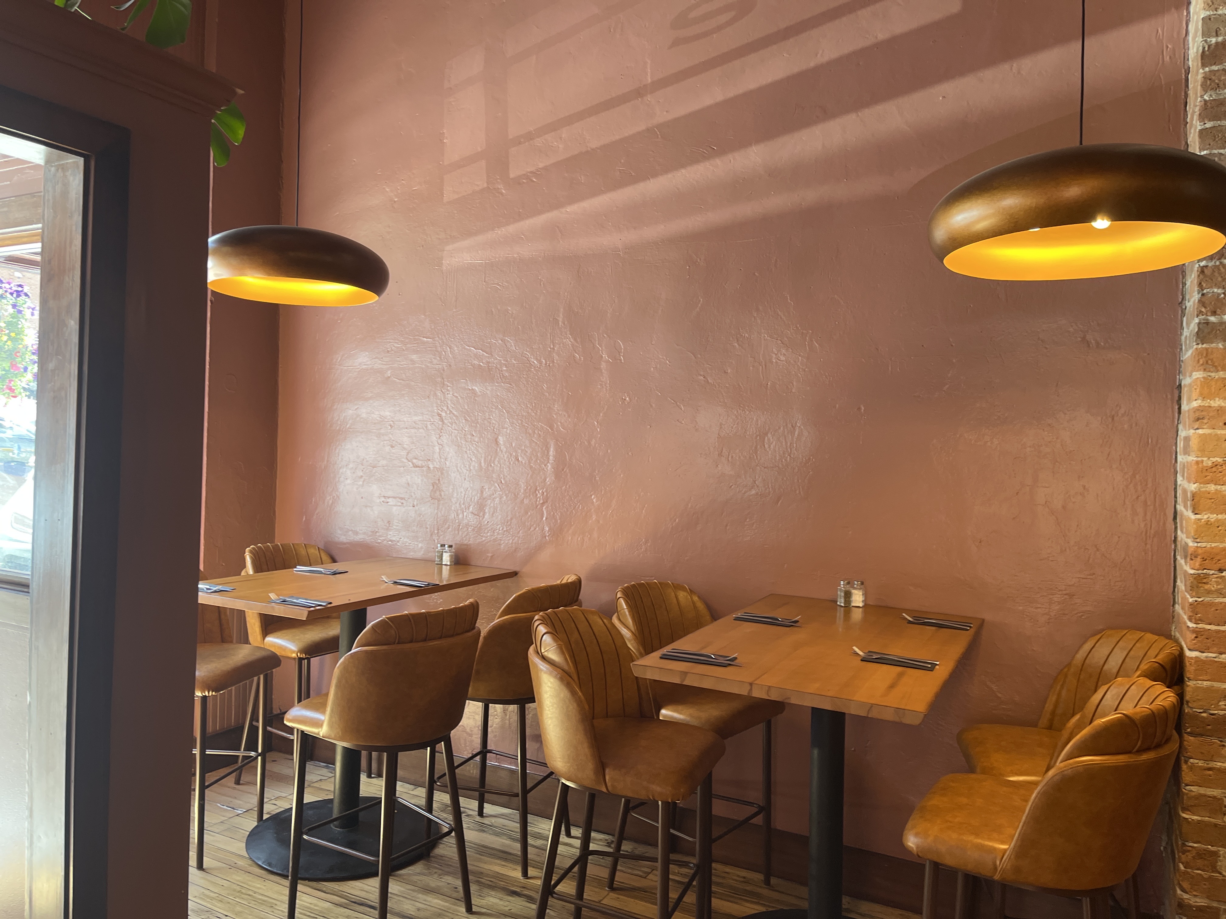 The Tavern dining room — copper pendant lighting and leather seating along terracotta walls.